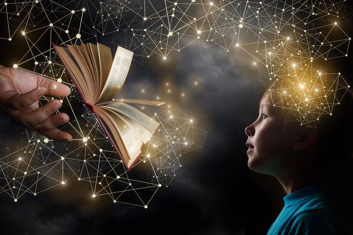 Open book on black background with child looking at it Open book on black background with child looking at it